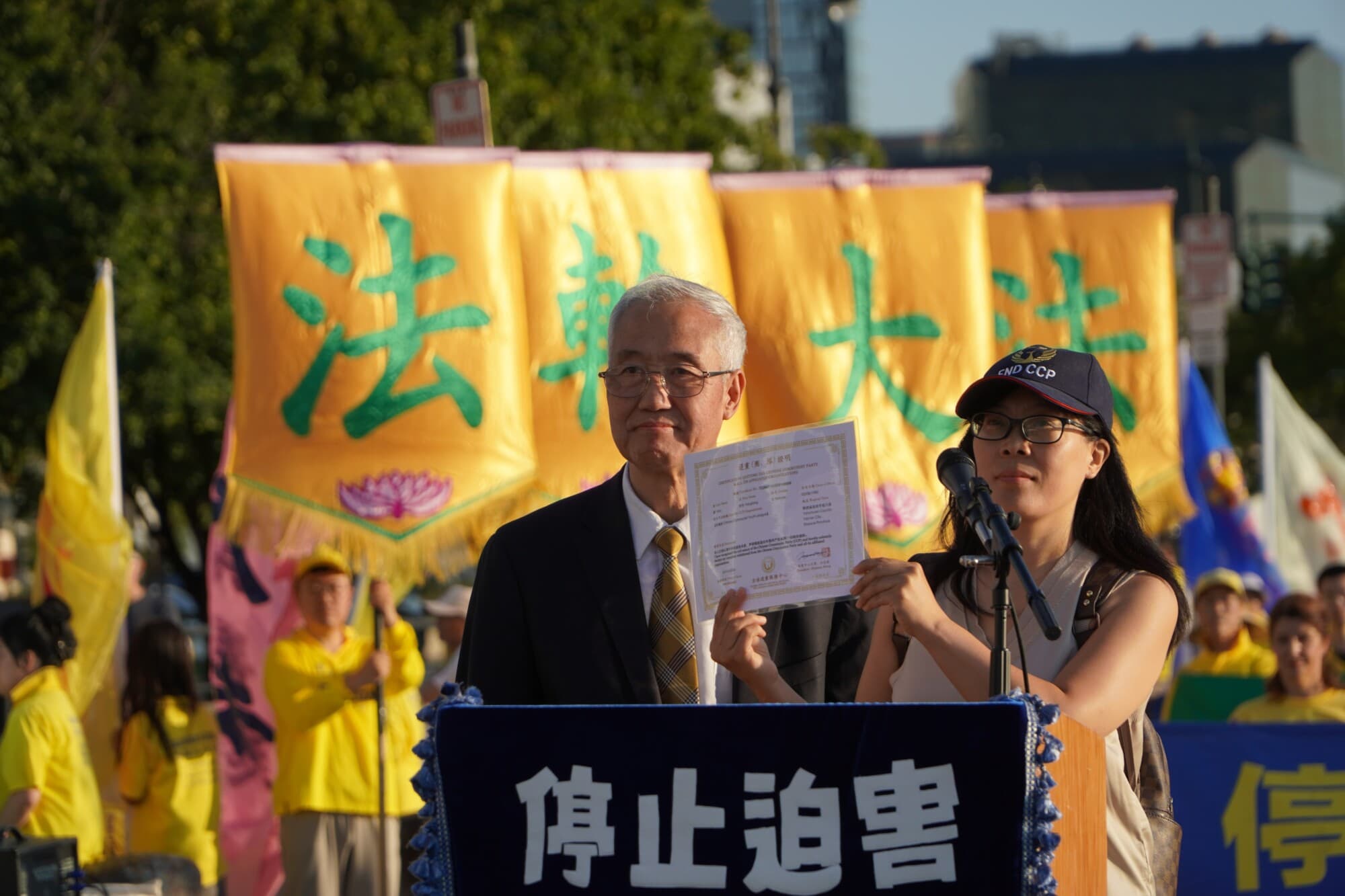 Hao Fangfang (derecha), mostrando su certificado que declara su decisión de renunciar al Partido Comunista Chino y a las organizaciones afiliadas, junto a Wang Zhiyuan, presidente del Centro de Servicios Globales para Renunciar al PCCh, en Nueva York el 20 de julio. (Nicholas Zifcak/ The Epoch Times).