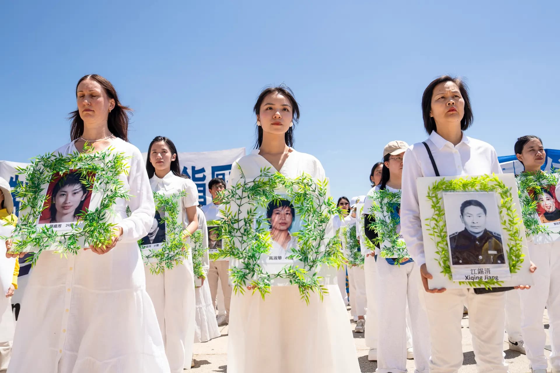 Practicantes de Falun Dafa sostienen fotos de compañeros practicantes que fueron perseguidos hasta la muerte por el Partido Comunista Chino en China, en el Monumento a Lincoln en Washington el 23 de julio de 2026. (Madalina Kilroy/The Epoch Times)