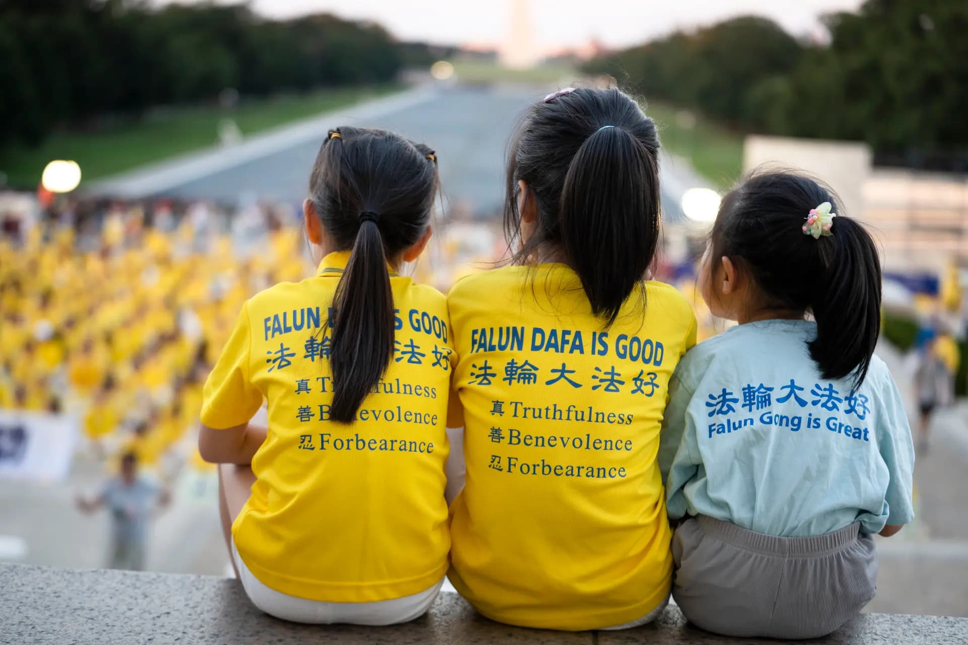 Tres jóvenes practicantes de Falun Dafa se sientan juntas en las escaleras del Monumento a Lincoln en Washington el 23 de julio de 2026. (Madalina Kilroy/The Epoch Times)