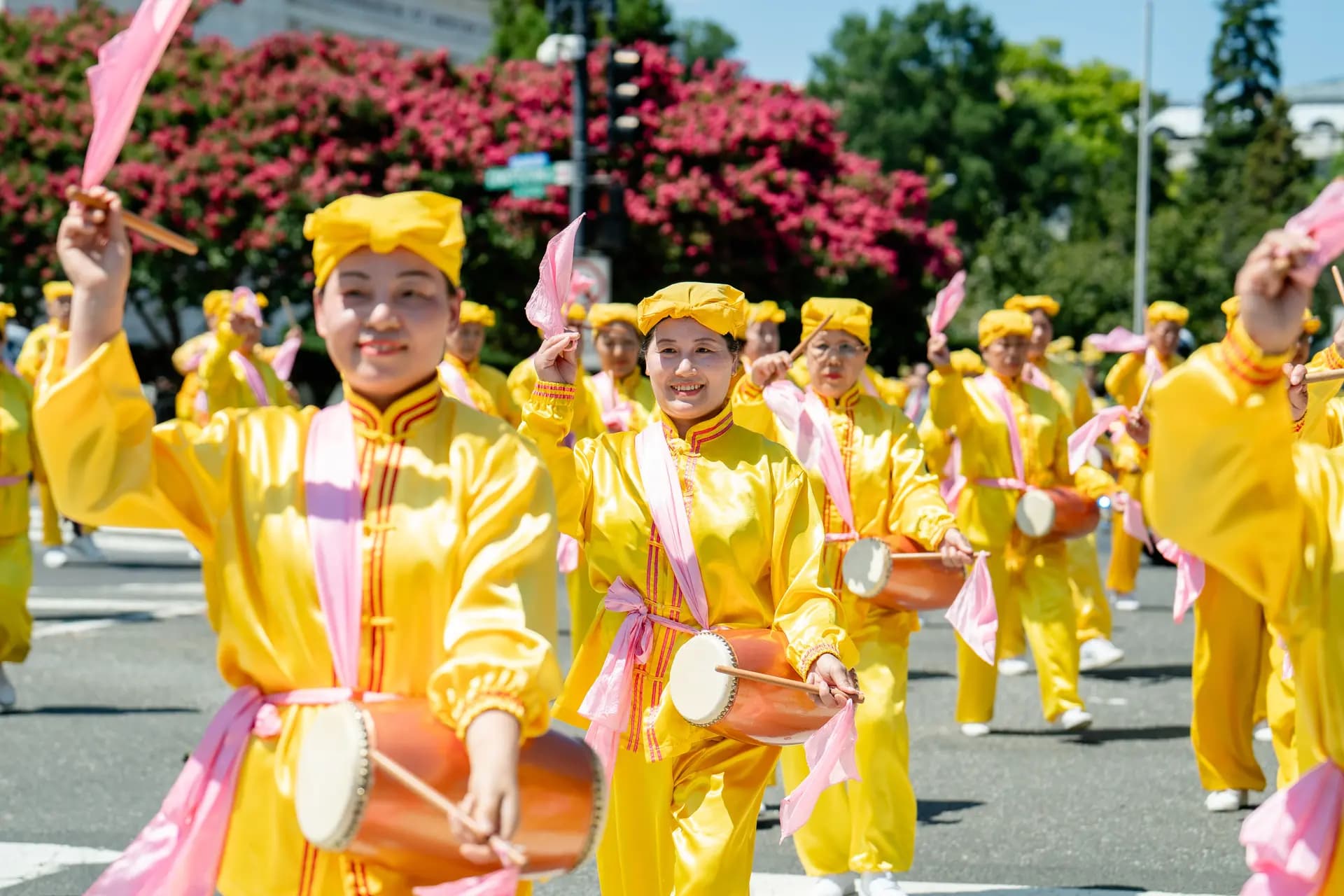 Un grupo de tambores de cintura formado por practicantes de Falun Dafa se presenta durante la marcha en Washington el 23 de julio de 2026. (Samira Bouaou/The Epoch Times)