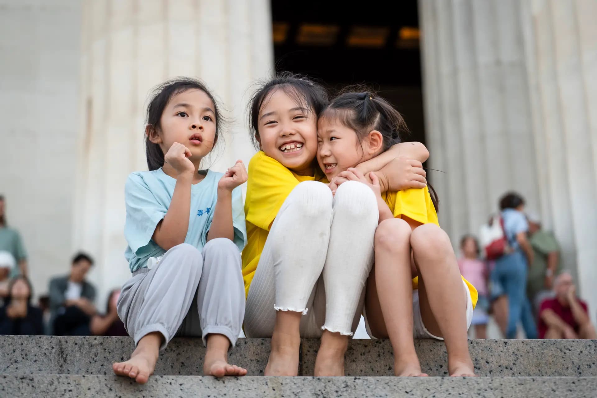 Unas niñas sonríen mientras los practicantes de Falun Dafa sostienen velas en Washington el 23 de julio de 2026. (Madalina Kilroy/The Epoch Times)