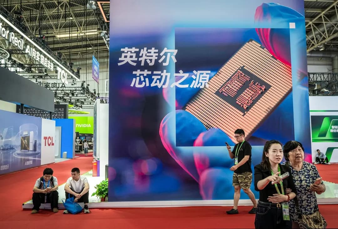 Personas cerca de una valla publicitaria que muestra un chip semiconductor, en la Exposición Internacional de la Cadena de Suministro de China, celebrada en Beijing el 26 de junio de 2026. China está invirtiendo fuertemente en inteligencia artificial y robótica, destinando miles de millones de dólares a lo que el gobierno considera el próximo motor económico del país. Como parte de la carrera por la IA, está recurriendo a tácticas de "segundo frente", como financiar protestas contra centros de datos en Estados Unidos, según los analistas. (Kevin Frayer/Getty Images)