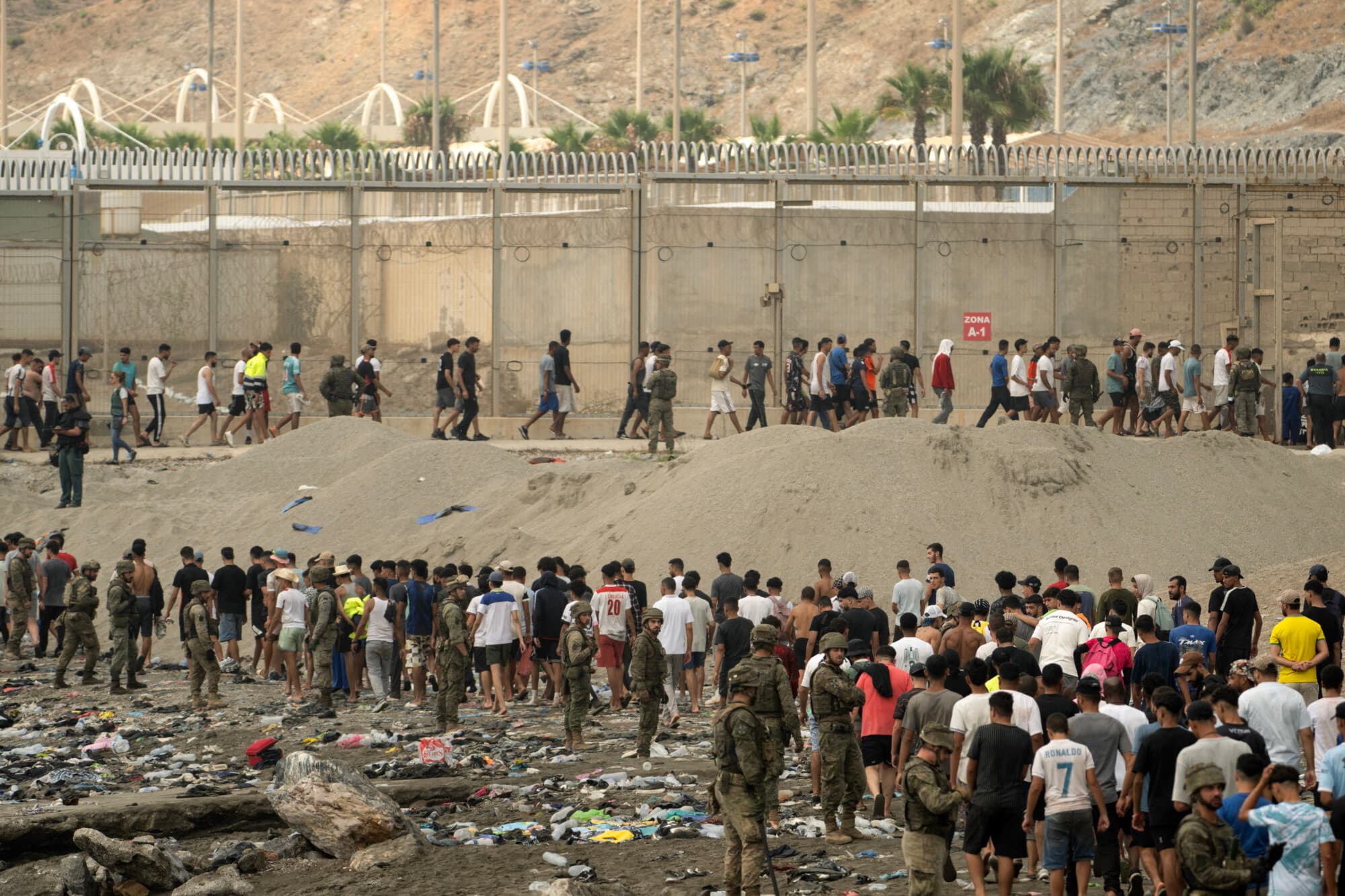 Soldados españoles controlan a los migrantes mientras estos regresan a Marruecos tras haber cruzado la frontera para ingresar al enclave español de Ceuta, en el norte de África, el 31 de julio de 2026. (JORGE GUERRERO / AFP vía Getty Images)