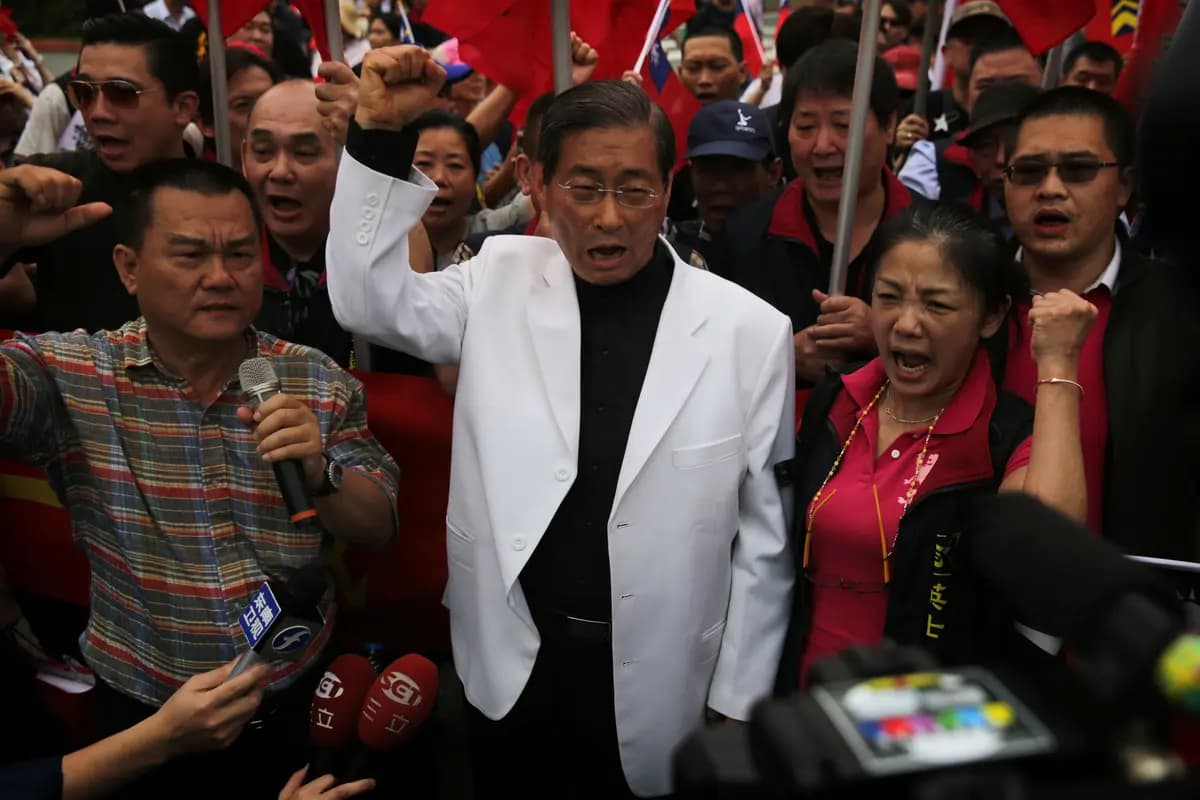 Foto de archivo de 2016 en la que aparece Chang An-lo (C), conocido como el "Lobo Blanco", líder del Partido para la Promoción de la Unificación de China (CUPP) y figura prominente vinculada al crimen organizado en Taiwán. (Isaac Lawrence/AFP/Getty Images)