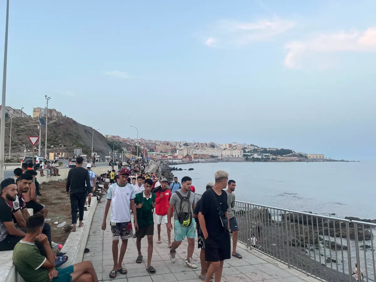 Inmigrantes ilegales marroquíes caminan por la Avenida Martínez Catena en Ceuta hacia la zona fronteriza el 31 de julio de 2026, a las 9:34 p. m. hora local. (Etienne Fauchaire/The Epoch Times)