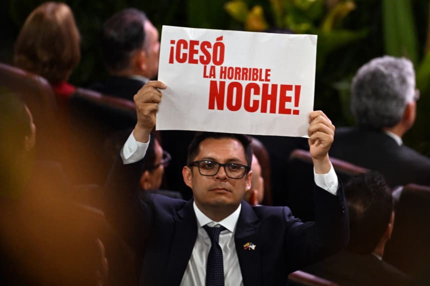 Un asistente sostiene un cartel con el mensaje '¡Ha terminado la horrible noche!' durante la ceremonia de juramentación del nuevo presidente de Colombia, Abelardo de la Espriella, en la Universidad Santiago de Cali, en Cali, Colombia, el 7 de agosto de 2026. (Foto de Luis ACOSTA / AFP via Getty Images)