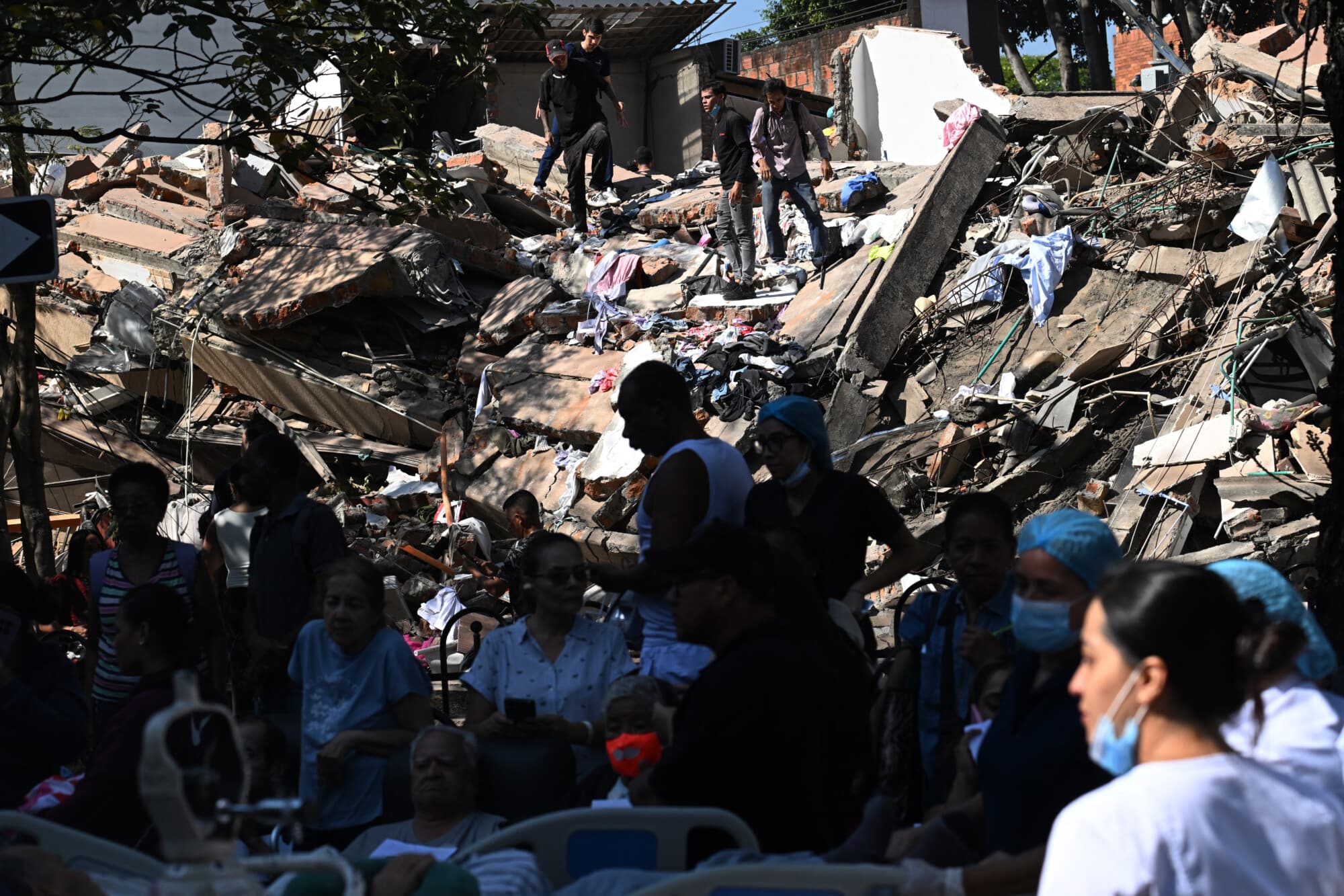 La gente busca sobrevivientes entre los escombros de un edificio derrumbado tras un terremoto en Cali, Colombia, el 10 de agosto de 2026. Un potente terremoto sacudió a Colombia y a los países vecinos de América Latina el 10 de agosto de 2026, y los equipos médicos se apresuraron a ayudar a las víctimas después de que varios edificios resultaran dañados o se derrumbaran en varias ciudades. El Servicio Geológico de Colombia y su contraparte estadounidense, el USGS, estimaron la magnitud en 7,4, con un epicentro a 100 km (60 millas) de profundidad en el oeste del país. Colombia la había estimado inicialmente en 6.6. (Joaquín SARMIENTO / AFP vía Getty Images)