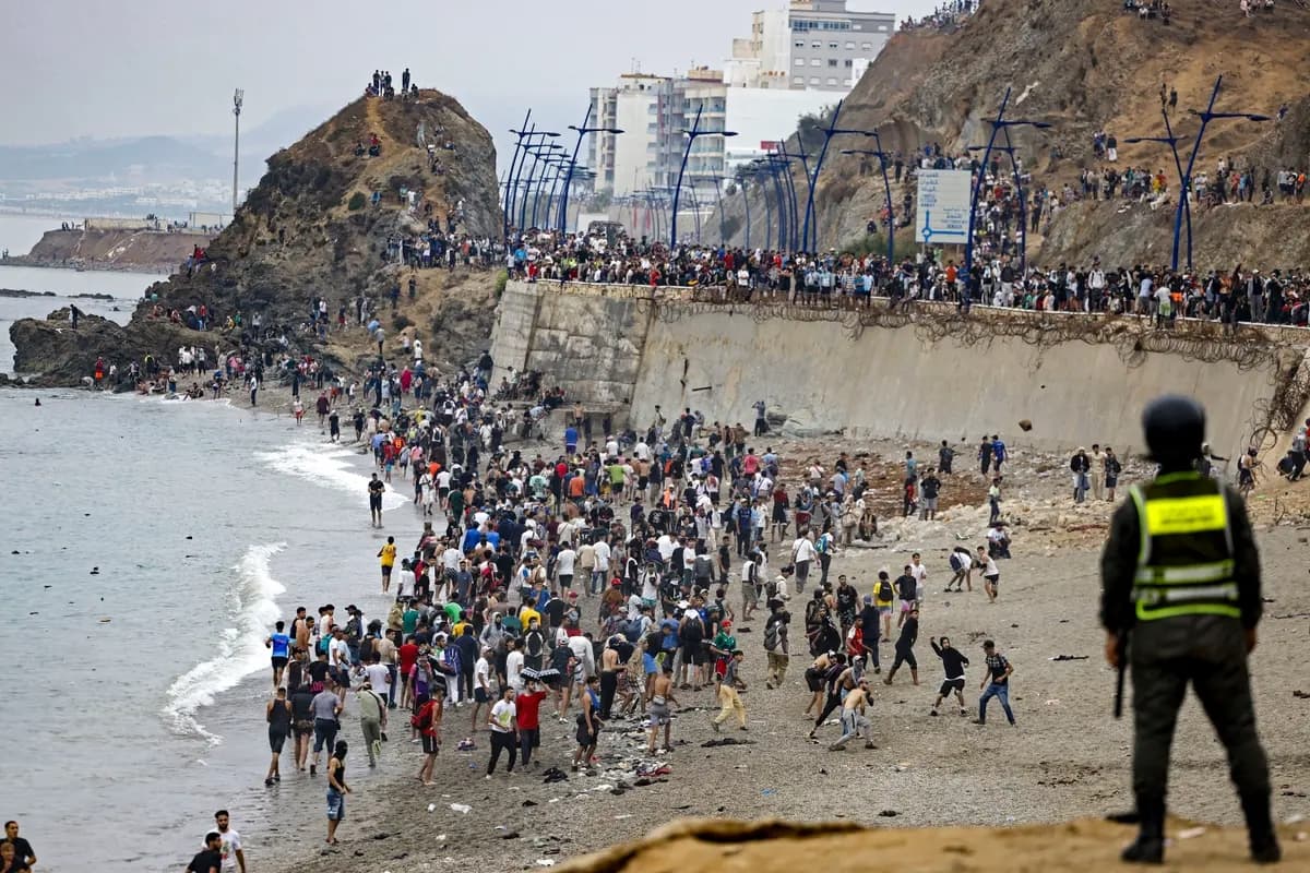 Inmigrantes ilegales se concentran junto a la valla en el lugar de los enfrentamientos cerca de Fnideq, en la frontera entre Marruecos y España, en Fnideq, Marruecos, el 31 de julio de 2026. (Abdel Majid Bziouat/AFP vía Getty Images)