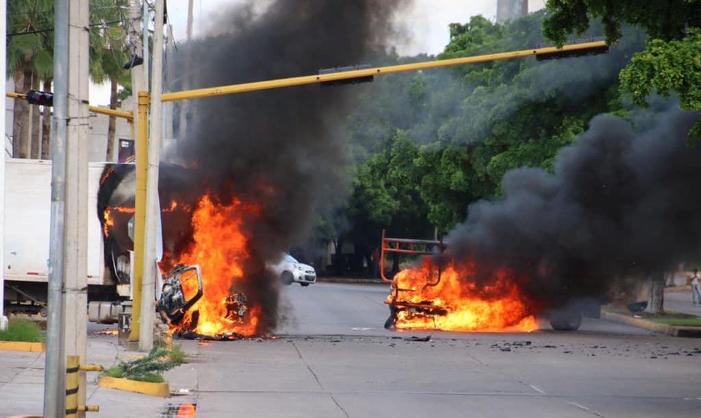 Vehículos arden en una calle de Culiacán, Sinaloa, México, el 17 de octubre de 2019. Hombres fuertemente armados, a bordo de camionetas todoterreno, se enfrentaron en un intenso combate con las fuerzas de seguridad mexicanas en Culiacán, capital del estado natal de Joaquín «el Chapo» Guzmán, entonces encarcelado. Foto: STR/AFP vía Getty Images