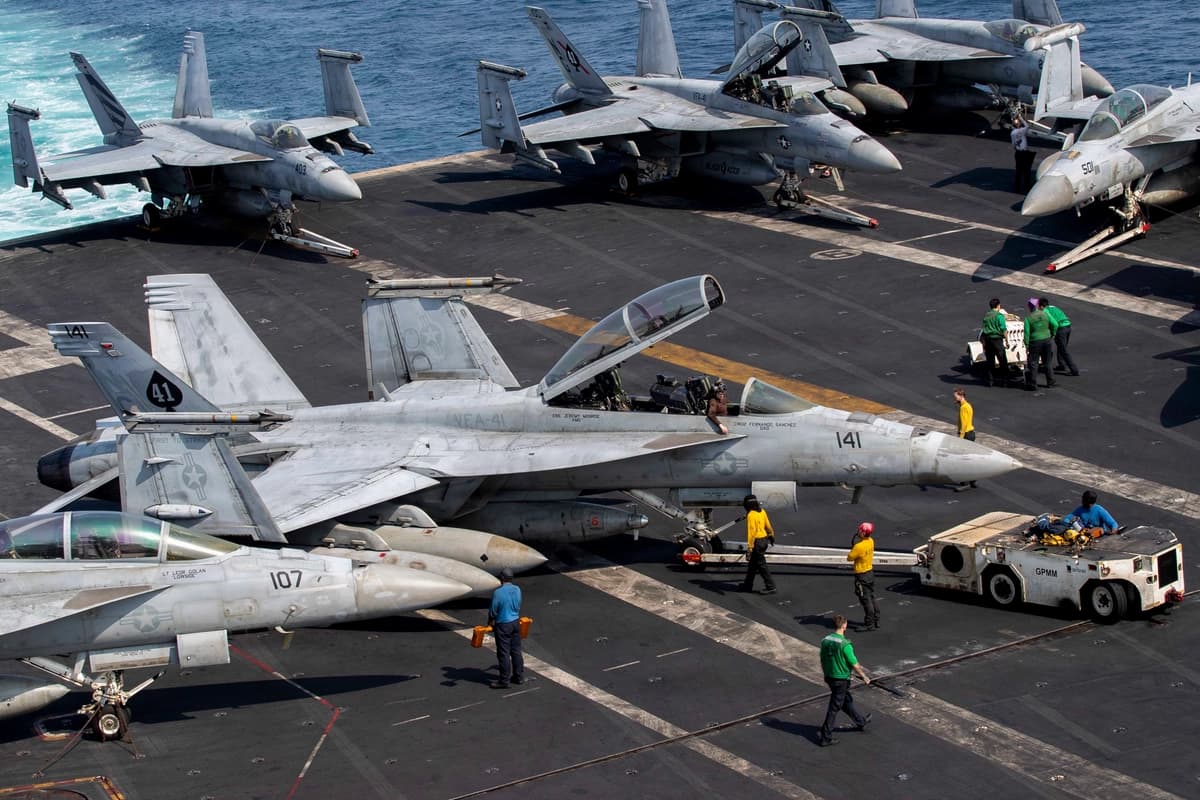 Marineros estadounidenses conducen un F/A-18F Super Hornet, adscrito al Escuadrón de Cazas de Ataque (VFA) 41, por la cubierta de vuelo a bordo del portaaviones clase Nimitz USS Abraham Lincoln, en apoyo a la Operación Epic Fury, el 17 de marzo de 2026. (Armada de los EE. UU.)
