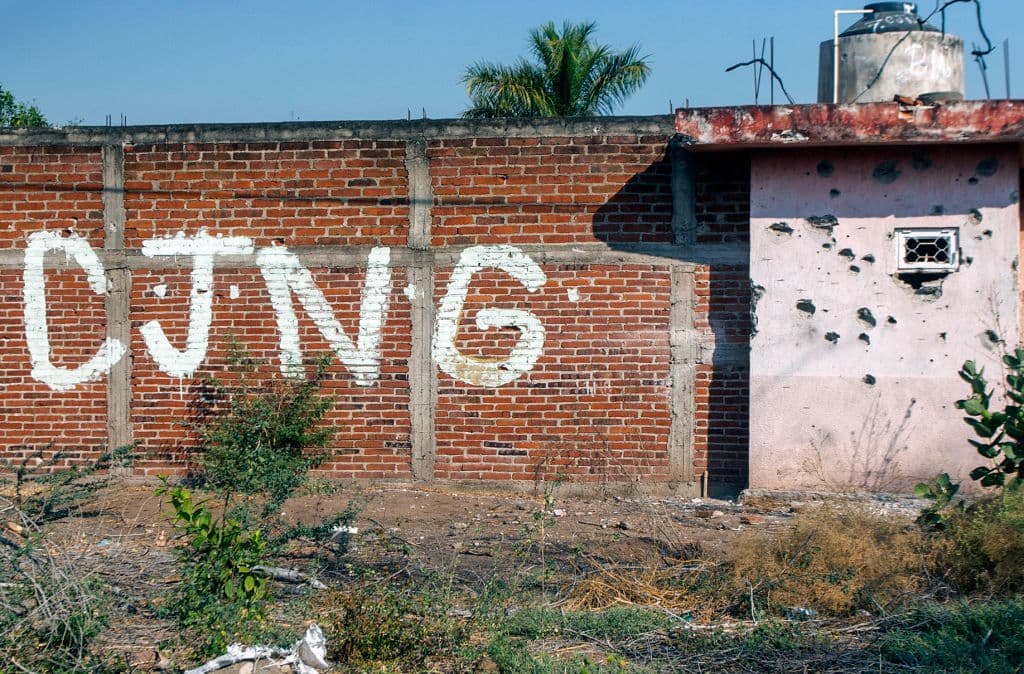 <em>Vista de un muro acribillado a balazos con las iniciales del grupo criminal Cártel Jalisco Nueva Generación (CJNG) a la entrada de la comunidad de Aguililla, en Michoacán, México, el 23 de abril de 2021. (ENRIQUE CASTRO/AFP vía Getty Images)</em>