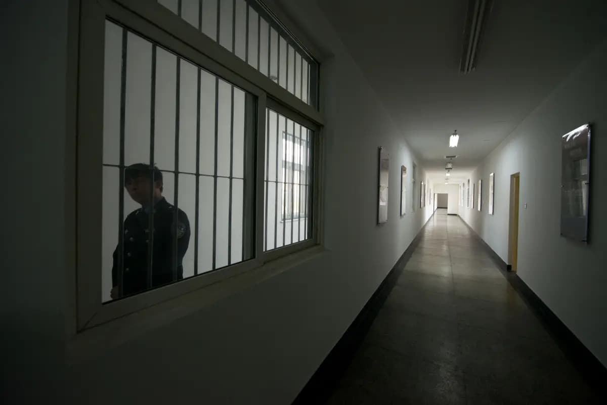 Un guardia mira a través de la ventana de un pasillo dentro de un centro de detención en Beijing el 25 de octubre de 2012. (Ed Jones/AFP vía Getty Images)