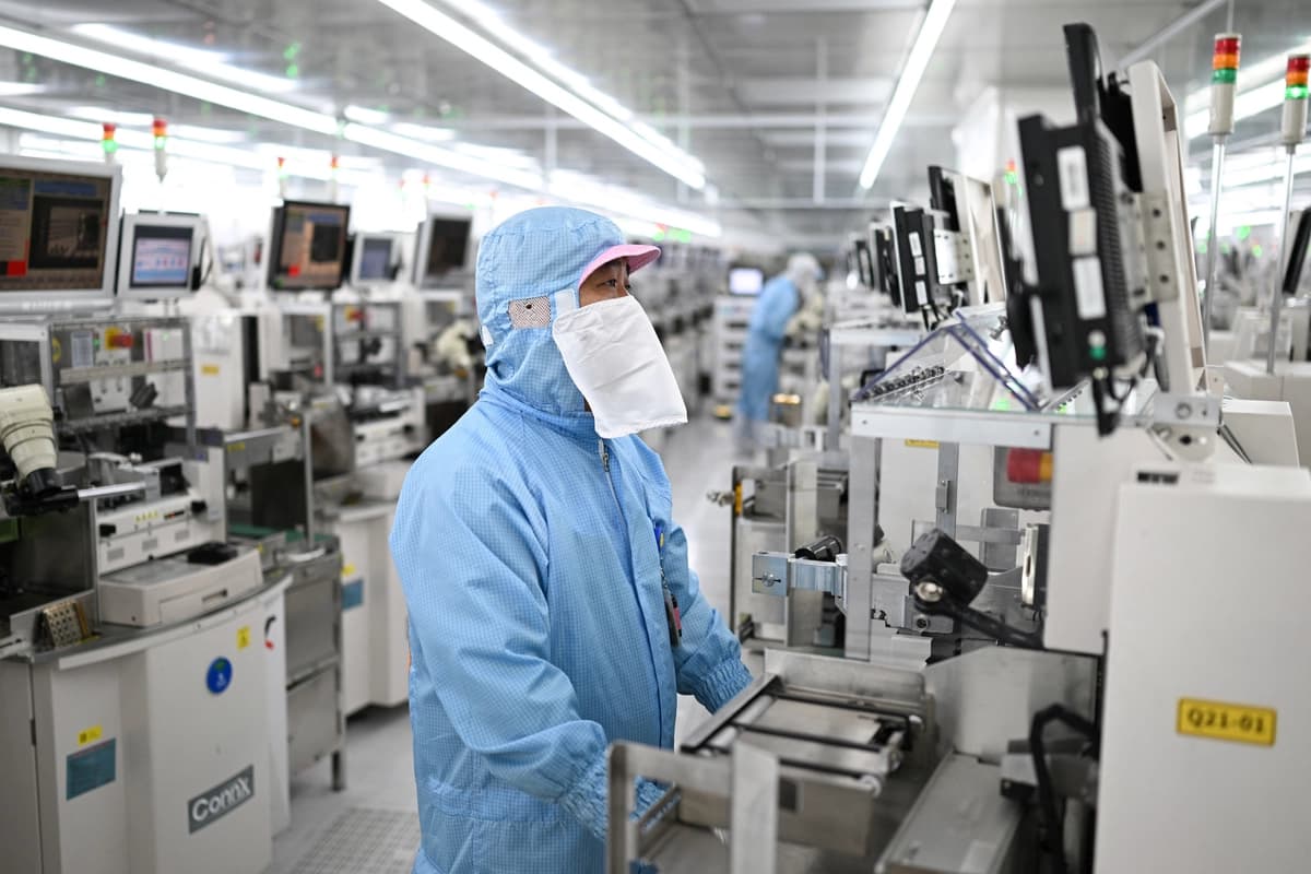 Técnicos trabajan en equipos de procesamiento de chips en una planta de fabricación de semiconductores en Suqian, provincia de Jiangsu, China, el 20 de octubre de 2025. (STR/AFP vía Getty Images)