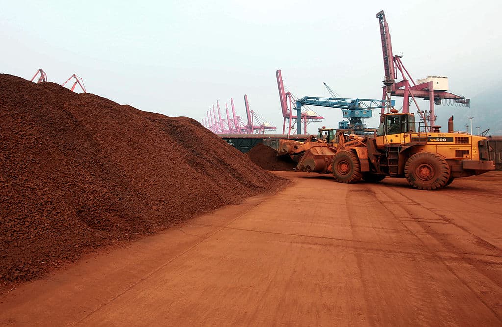 Un hombre que conduce una pala cargadora mueve tierra que contiene minerales de tierras raras para cargarla en un puerto en Lianyungang, provincia de Jiangsu, este de China, para exportarla a Japón, el 5 de diciembre de 2010. (STR/AFP vía Getty Images)