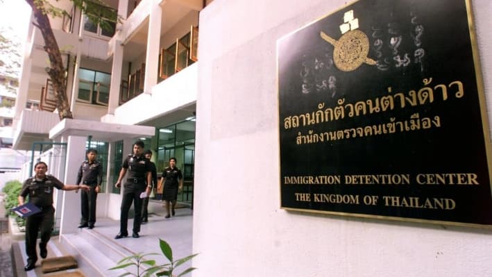 Los agentes de inmigración tailandeses abandonan el Centro de Detención de Inmigrantes de Bangkok, el 11 de enero del 2000. (Pornchai Kittiwongsakul/AFP vía Getty Images)