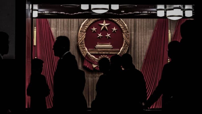 Delegados y guardias de seguridad se encuentran en la entrada del auditorio antes de la sesión de clausura del Congreso Nacional Popular en el Gran Salón del Pueblo en Beijing, el 11 de marzo de 2024. (Kevin Frayer/Getty Images)