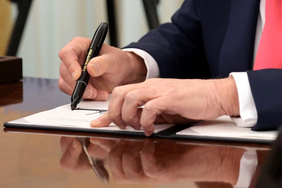 El presidente Donald Trump firma órdenes ejecutivas en el Despacho Oval de la Casa Blanca el 6 de marzo de 2025, en Washington. (Alex Wong/Getty Images)