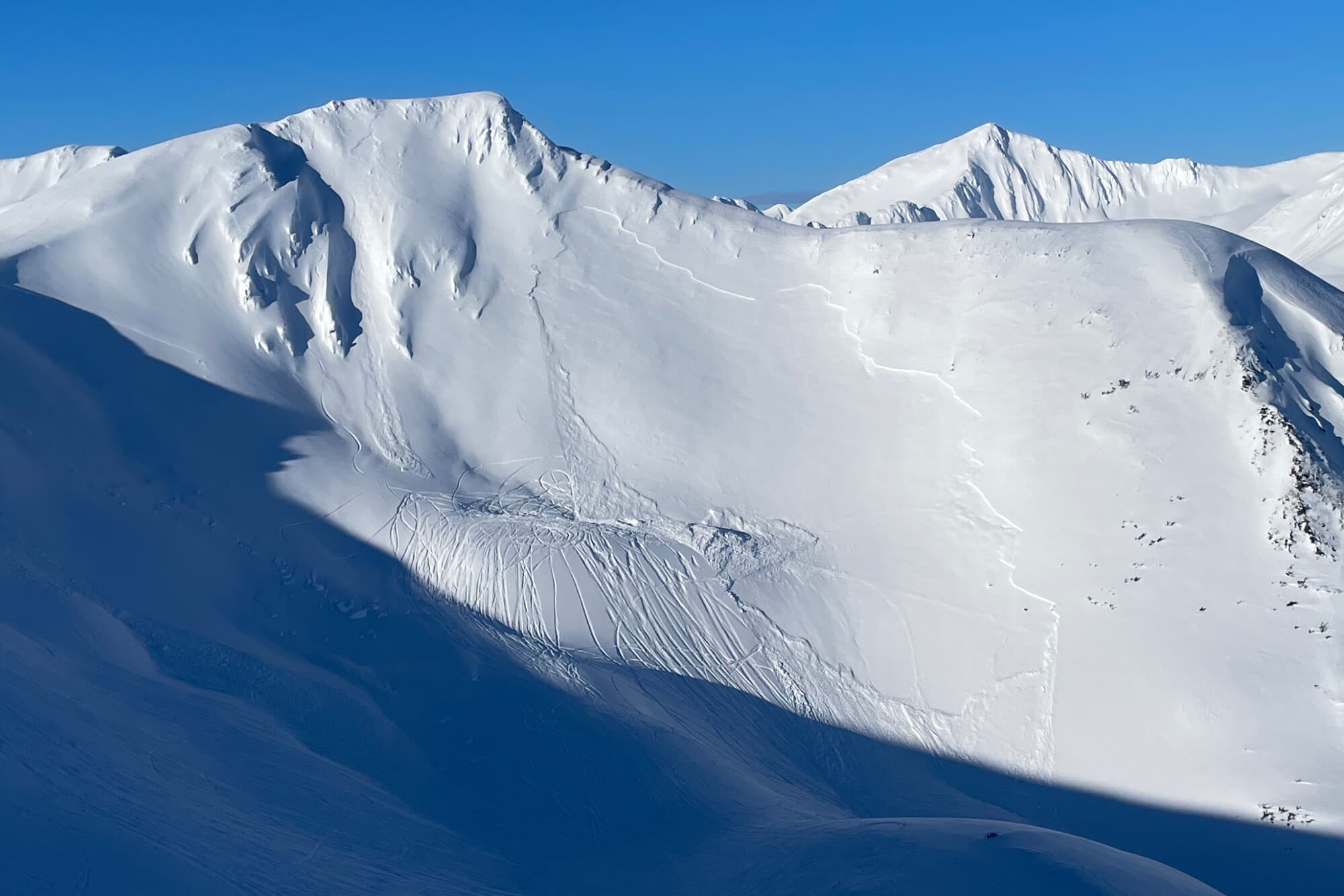 Este domingo 23 de marzo de 2025, la imagen publicada por el Centro de Avalanchas del Bosque Nacional de Chugach muestra las secuelas de una avalancha de placa que mató a un conductor de máquina de nieve, el sábado 22 de marzo en Turnagain Pass, Alaska. (Centro de Avalanchas del Bosque Nacional de Chugach a través de AP)