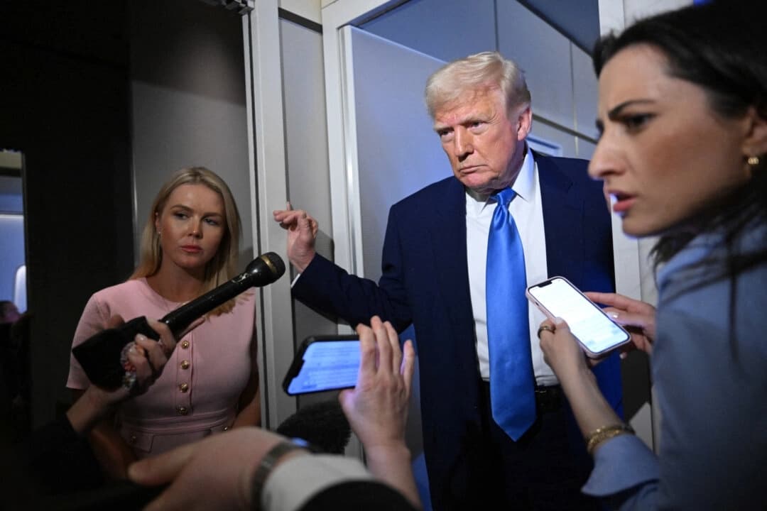 La secretaria de prensa de la Casa Blanca, Karoline Leavitt, escucha (izquierda) mientras el presidente de los Estados Unidos, Donald Trump, habla con los periodistas durante el vuelo en el Air Force One, de camino a la Base Conjunta Andrews, el 6 de abril de 2025. (Mandel Ngan/AFP a través de Getty Images)