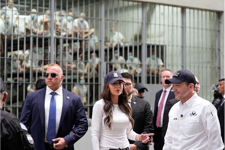 Presos observan tras las rejas mientras la Secretaria de Seguridad Nacional de EE.UU., Kristi Noem, acompañada por el Ministro de Justicia y Seguridad Pública, Gustavo Villatoro (R), recorre el Centro de Reclusión de Terroristas (CECOT) en Tecoluca, El Salvador, el 26 de marzo de 2025. (Alex Brandon/Pool/AFP vía Getty Images)