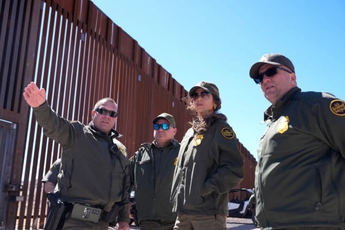La secretaria de Seguridad Nacional, Kristi Noem (segunda desde la derecha), escucha durante un recorrido por el muro fronterizo de Nogales en el puerto de entrada de Mariposa, en Nogales, Arizona, el 15 de marzo de 2025. (Alex Brandon/AFP vía Getty Images)