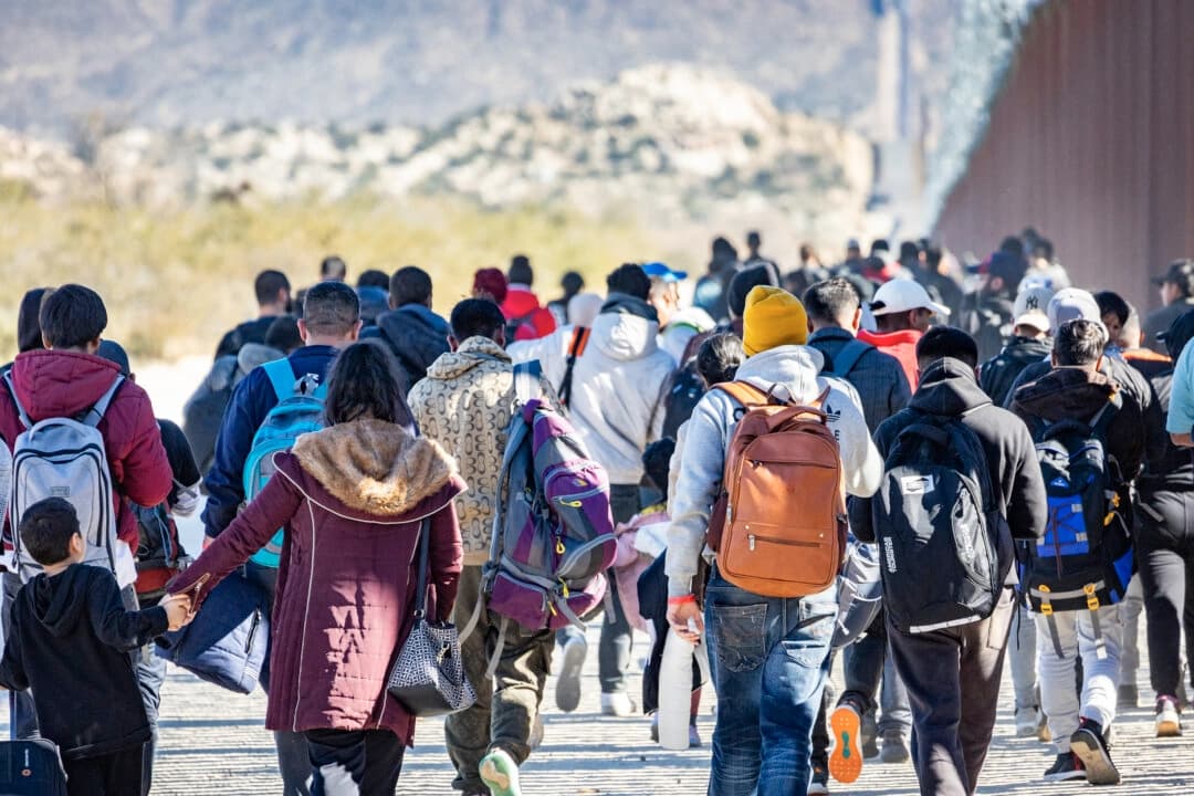 Migrantes que cruzaron ilegalmente a Estados Unidos esperan ser procesados por agentes de la Patrulla Fronteriza de EE. UU. en las afueras de San Diego, California, el 5 de diciembre de 2023. (John Fredricks/The Epoch Times)
