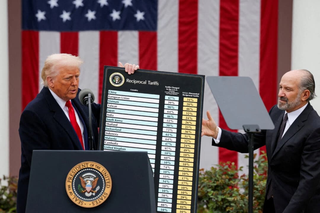 El presidente de Estados Unidos, Donald Trump, sostiene un gráfico junto al secretario de Comercio, Howard Lutnick, mientras Trump pronuncia un discurso sobre aranceles en el jardín de rosas de la Casa Blanca, en Washington, el 2 de abril de 2025. (Carlos Barria/Reuters)