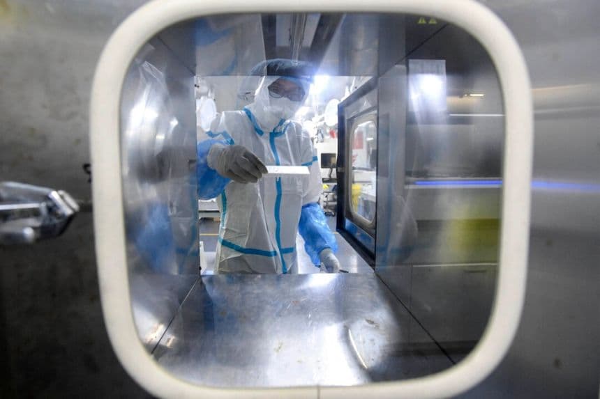 Un técnico de laboratorio trabaja con muestras que se analizarán para detectar el COVID-19 en el laboratorio Fire Eye, un centro de pruebas de COVID-19, en Wuhan, China, el 5 de agosto de 2021. (STR/AFP a través de Getty Images)
