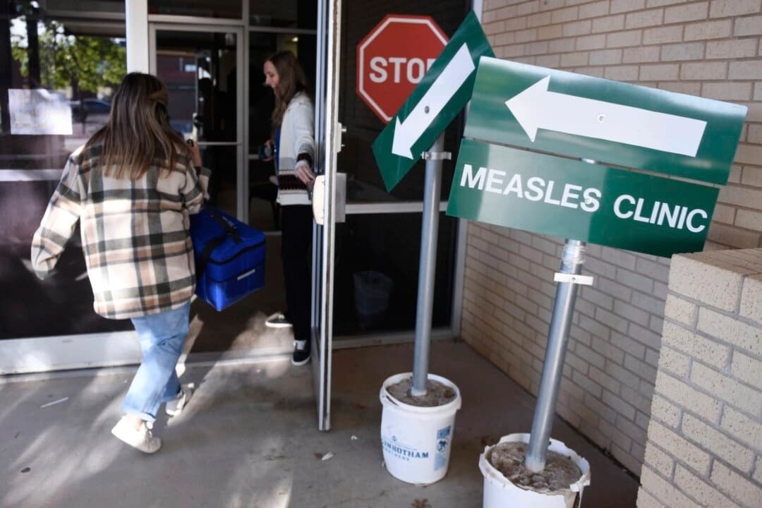 Miembros del personal del departamento de salud entran en la clínica contra el sarampión del Departamento de Salud del Condado de Andrews, en Andrews, Texas, el 8 de abril de 2025. (Annie Rice/AP Photo)