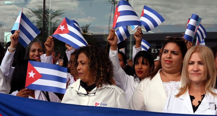 Médicos cubanos ondean banderas cubanas al llegar al Aeropuerto Internacional de Palmerola, a 50 km al norte de Tegucigalpa, el 27 de febrero de 2024. El brigada de 100 médicos especialistas permanecerá en Honduras durante dos años e incluye anestesistas, oncólogos, neurocirujanos, cardiólogos y endocrinólogos. (ORLANDO SIERRA/AFP vía Getty Images)