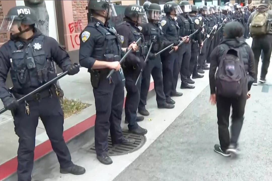 Manifestantes se enfrentan a la policía en San Francisco el 8 de junio de 2025, en una imagen fija de un vídeo. (AP/Captura de pantalla vía The Epoch Times)