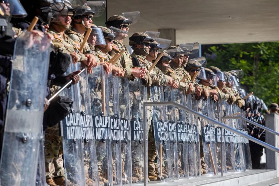 Miembros de la Guardia Nacional de California montan guardia frente al edificio federal mientras continúan las protestas en respuesta a las operaciones federales de inmigración en Los Ángeles el 10 de junio de 2025. (Apu Gomes/AFP a través de Getty Images)