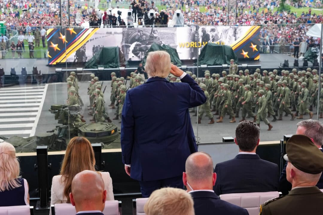 El presidente Donald Trump se pone en pie y saluda a las tropas durante la celebración del 250.º aniversario del Ejército en el National Mall el 14 de junio de 2025. (Doug Mills - Pool/Getty Images)