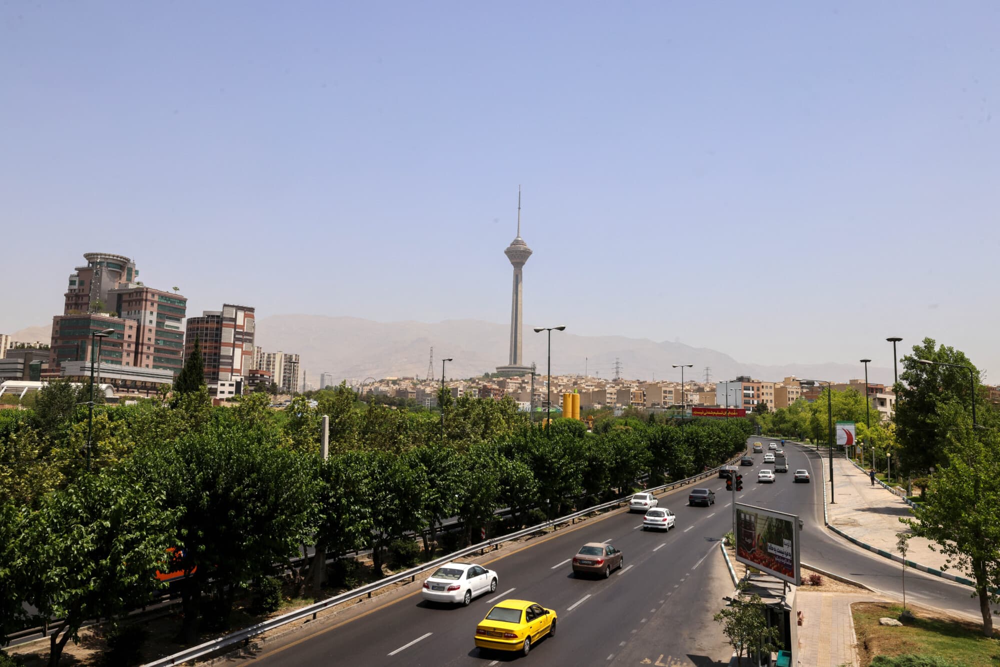 Vehículos circulan por una carretera principal con la Torre Milad de Teherán al fondo, el 24 de junio de 2025. (Atta Kenare/AFP vía Getty Images)