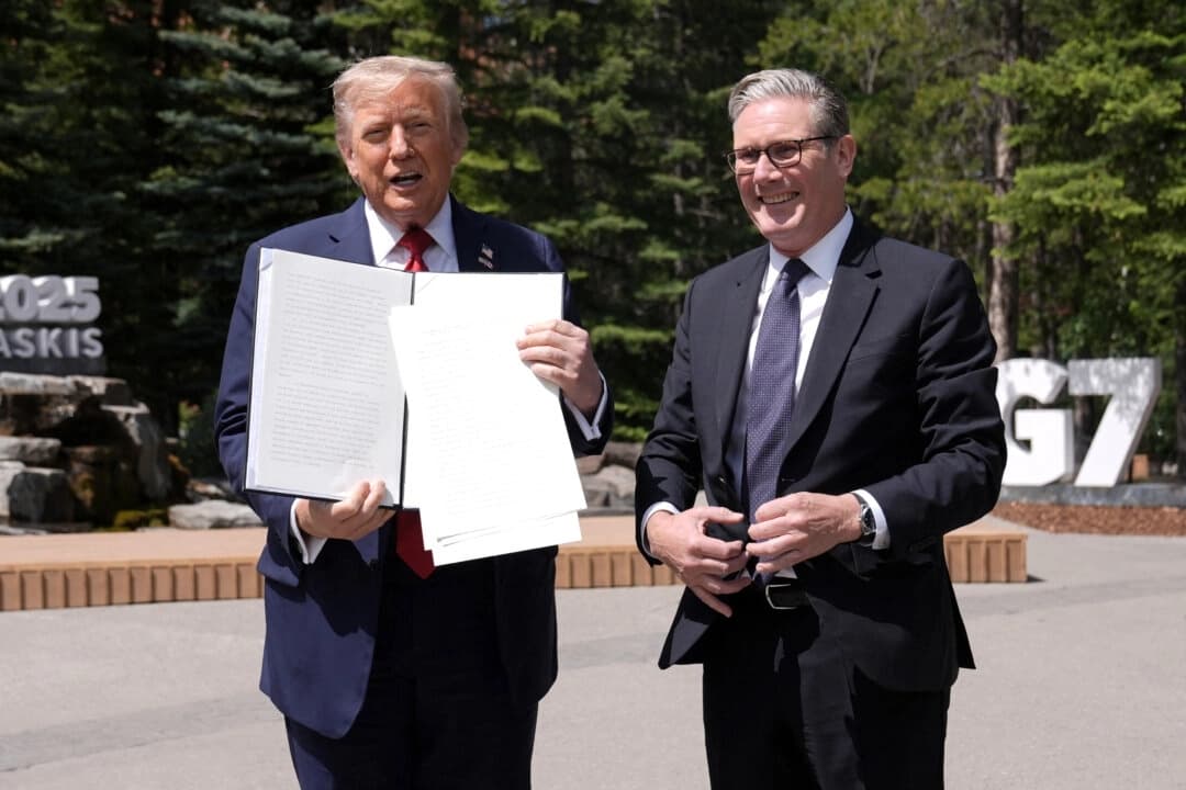 El presidente de Estados Unidos, Donald Trump (izquierda), sostiene un acuerdo comercial firmado entre Estados Unidos y el Reino Unido junto al primer ministro británico, Keir Starmer, mientras hablan con los periodistas durante la cumbre del Grupo de los Siete (G7) en el Pomeroy Kananaskis Mountain Lodge en Kananaskis, Alberta (Canadá), el 16 de junio de 2025. (Stefan Rousseau/Pool/AFP a través de Getty Images)