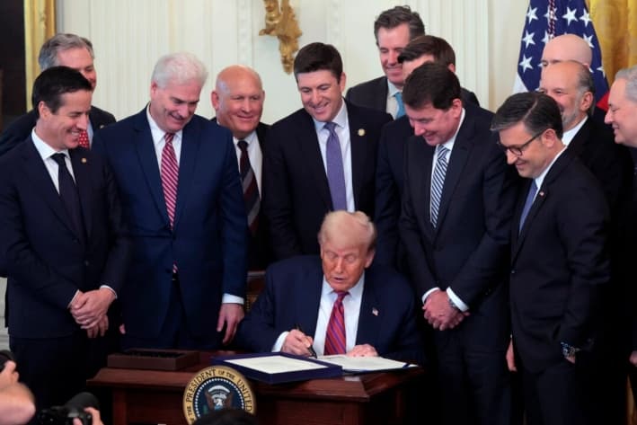 El presidente de Estados Unidos, Donald Trump, rodeado de legisladores, promulga la Ley GENIUS durante una ceremonia en la Sala Este de la Casa Blanca, en Washington, el 18 de julio de 2025. (Anna Moneymaker/Getty Images)