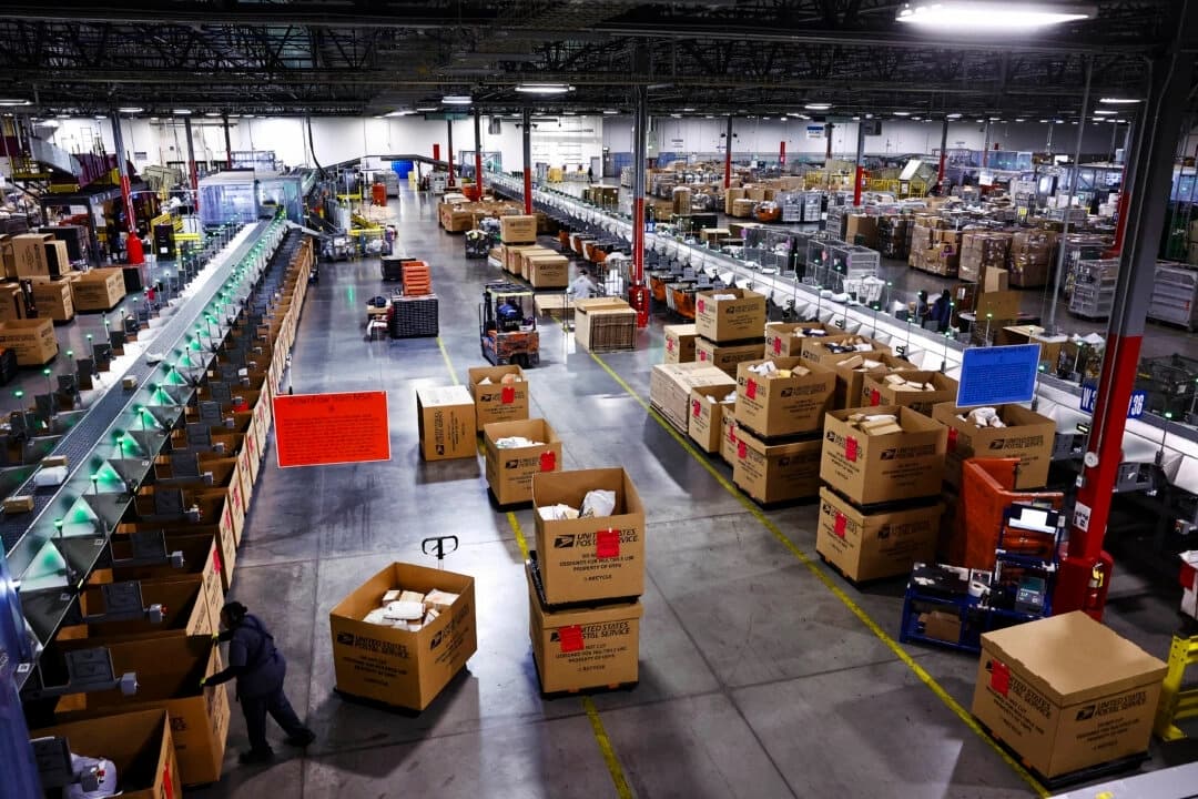 Los empleados del Servicio Postal de EE. UU. trabajan durante el inicio de la temporada alta de envíos navideños en el Centro de Procesamiento y Distribución Postal de Los Ángeles, el 3 de diciembre de 2024. (Mario Tama/Getty Images)