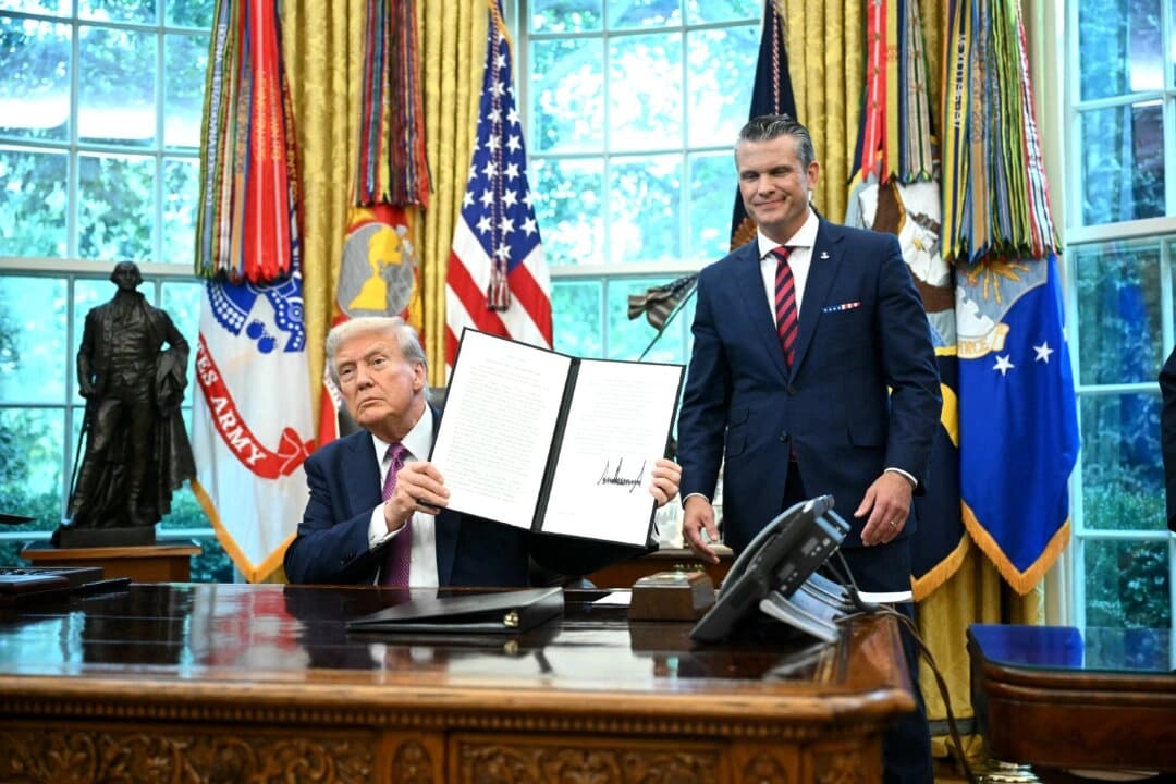 El presidente Donald Trump (izq.) muestra una orden ejecutiva firmada junto al secretario de Defensa, Pete Hegseth, en la Oficina Oval de la Casa Blanca el 5 de septiembre de 2025. (Mandel Ngan/AFP vía Getty Images)