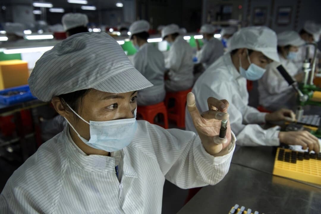 Un trabajador revisa un cartucho en la línea de producción de una empresa de cigarrillos electrónicos, en Shenzhen, China, el 25 de septiembre de 2019. (Kevin Frayer/Getty Images)