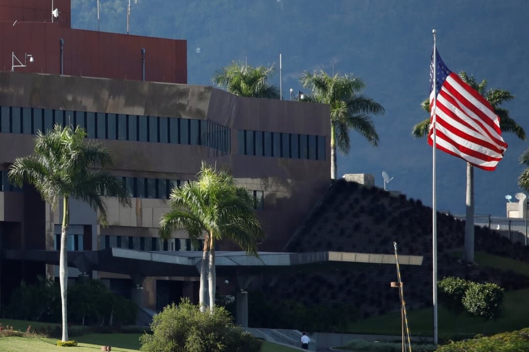 Un hombre camina junto a una bandera estadounidense en la embajada de Estados Unidos en Caracas, Venezuela, el 24 de enero de 2019. (Carlos García Rawlins/Reuters)