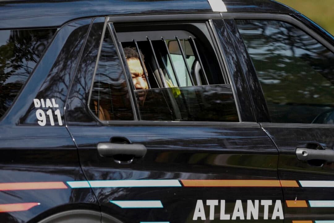 Derrick Groves, el último fugitivo de la fuga de la cárcel de Nueva Orleans en mayo, sentado en un vehículo policial tras ser detenido por los marshals estadounidenses y la policía de Atlanta en una casa del suroeste de Atlanta, el 8 de octubre de 2025. (Ben Hendren/Atlanta Journal-Constitution vía AP)