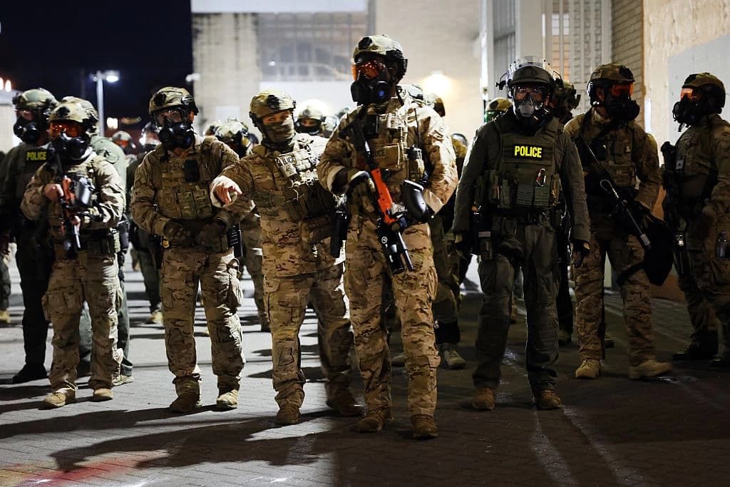 Agentes federales y políticas mantienen a raya a los manifestantes frente a una instalación del Servicio de Inmigración y Control de Aduanas de EE. UU. en Portland, Oregón, el 5 de octubre de 2025. (Spencer Platt/Getty Images)