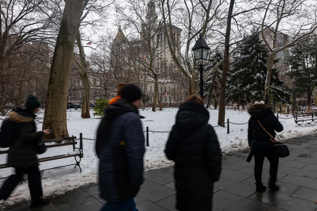 NEW YORK, NEW YORK - FEBRUARY 12: People walk through City Hall Park after a snow storm in Manhattan on February 12, 2025 in New York City. The metro area received up to three inches of snow with more expected this evening as much of the Northeast experiences cold temperatures. (Photo by Spencer Platt/Getty Images)