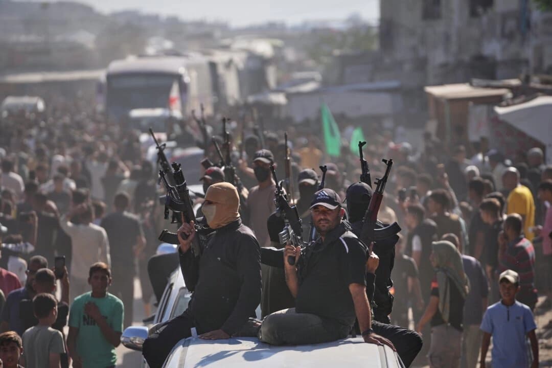 Hombres armados de Hamás en camionetas escoltan autobuses que transportan a prisioneros palestinos liberados mientras son recibidos tras su liberación de las cárceles israelíes en virtud de un acuerdo de alto el fuego entre Hamás e Israel, en Jan Yunis, al sur de la Franja de Gaza, el 13 de octubre de 2025. (Jehad Alshrafi/AP Photo)