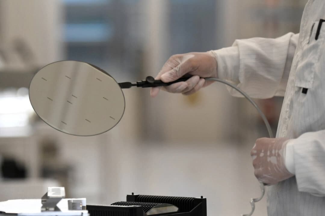Un empleado trabaja con una oblea en una línea de producción de la empresa holandesa de semiconductores Nexperia, en Hamburgo, Alemania, el 27 de junio de 2024. (Fabian Bimmer/Reuters)