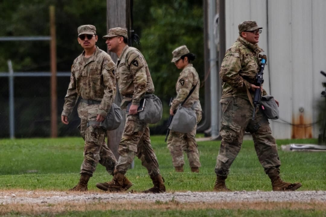 Soldados de la Guardia Nacional de Texas caminan por el Centro de Entrenamiento de la Reserva del Ejército de Joliet, después de que el presidente de Estados Unidos, Donald Trump, ordenara aumentar la presencia de las fuerzas del orden federales para ayudar en la prevención del delito, en Elwood, Illinois, el 7 de octubre de 2025. (Jim Vondruska/Reuters)