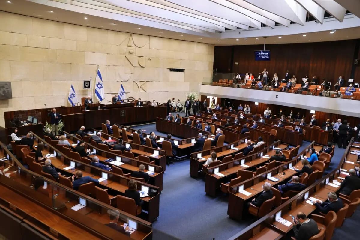 Legisladores israelíes asisten a la ceremonia de juramentación del 24.° gobierno de Israel, en la Knesset, o parlamento, en Jerusalén, Israel, el 6 de abril de 2021. (Alex Kolomoisky/Pool vía AP)
