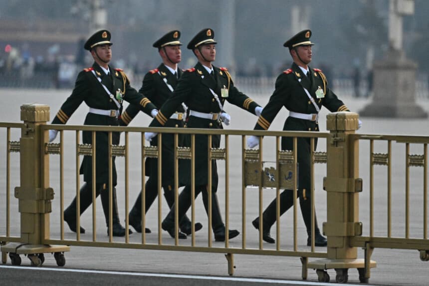Miembros de la policía paramilitar china patrullan la plaza de Tiananmen antes de la sesión inaugural de la Asamblea Popular Nacional, en el Gran Salón del Pueblo de Beijing, el 5 de marzo de 2025. (Pedro Pardo/AFP vía Getty Images)
