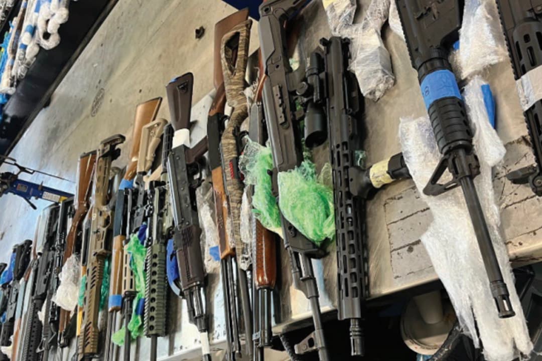 Varias armas de fuego puestas sobre una mesa tras una incautación en el puerto de entrada Juárez-Lincoln en Laredo, Texas, el 23 de octubre. (Departamento de Justicia de los Estados Unidos).