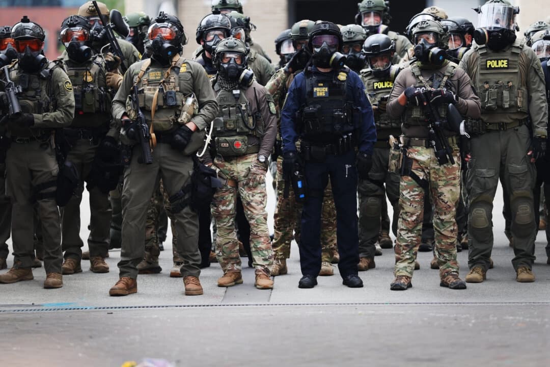 Agentes federales, entre ellos miembros del Departamento de Seguridad Nacional, la Patrulla Fronteriza y la policía, se enfrentan a manifestantes frente a las instalaciones del Servicio de Inmigración y Control de Aduanas (ICE) en el centro de Portland, Oregón, el 4 de octubre de 2025. (Spencer Platt/Getty Images).